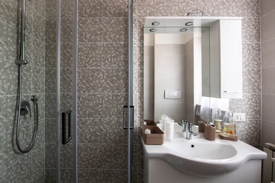 Shower and basin with lit mirror